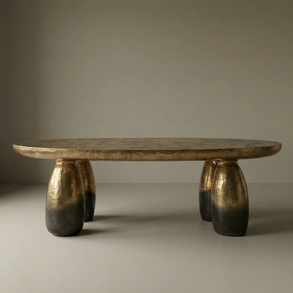 Front view of the Solum dining table by Diamant Versatile, with an elongated bronze top and rounded sculptural legs.